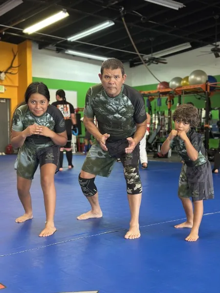 George Fujii and two students in fighting stance on the mat